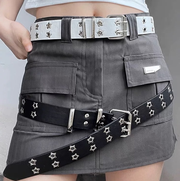 Gray skirt with black and silver studded belts on a plain background