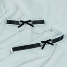 Two black satin sweet lolita maid choker with lace detailing on a white fabric background