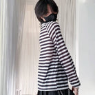 Person wearing a black and white striped shirt with a blurred background