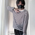 Person wearing a black and white striped shirt with a plain background