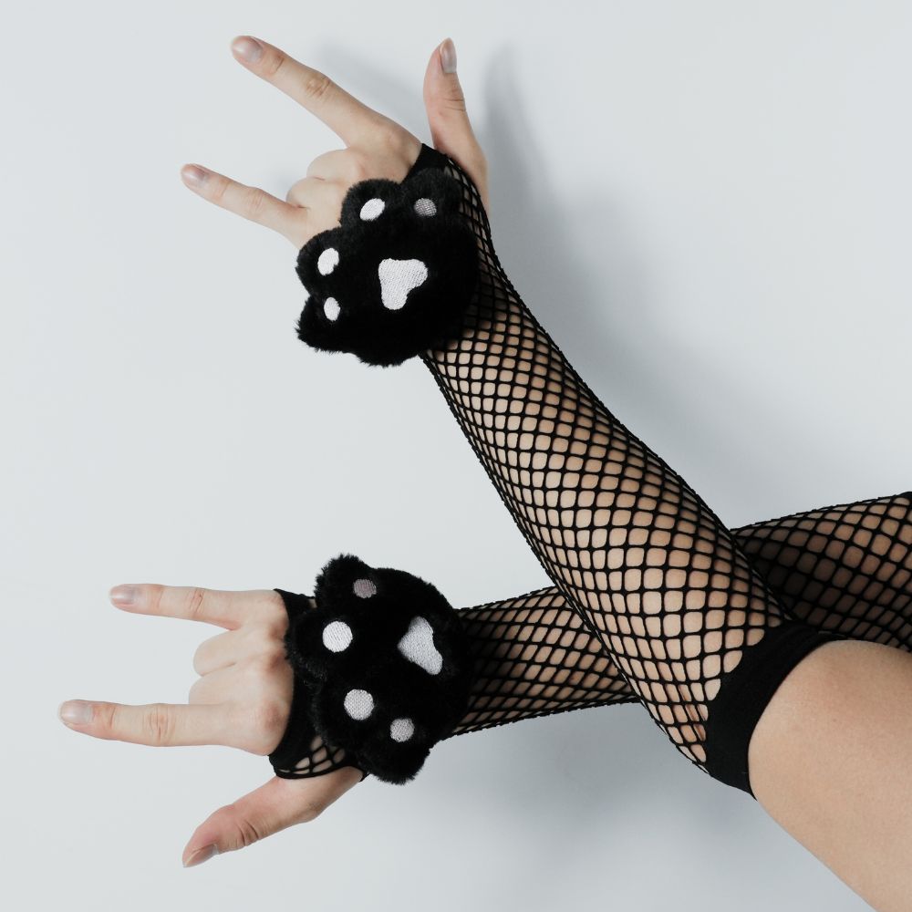 Black fishnet gloves with pink paw prints worn by a person on a light gray background