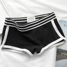 Black boyshorts panty with white trim on a light gray background