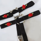 Black garters with red rose embroidery and silver cat-shaped buckles on a white background
