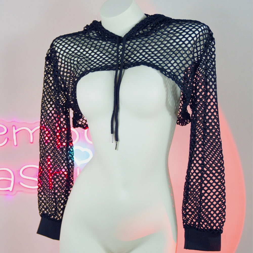Black fishnet crop top on a mannequin with a neon sign in the background