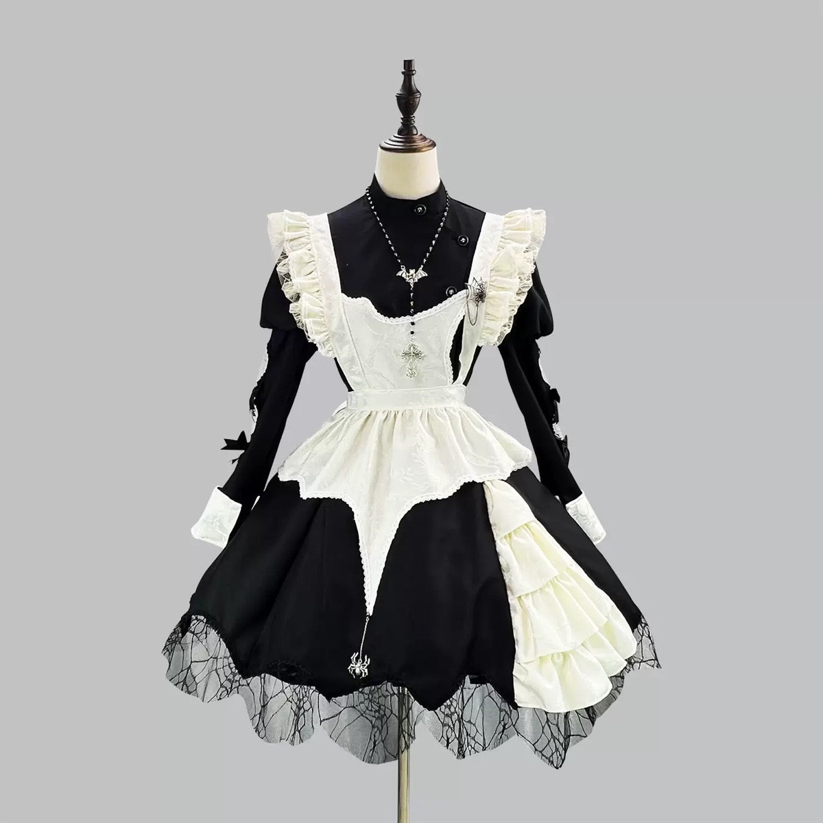 Black and white gothic maid dress on a mannequin against a gray background