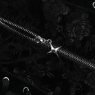 Silver zipper with a star-shaped pull on a black floral background