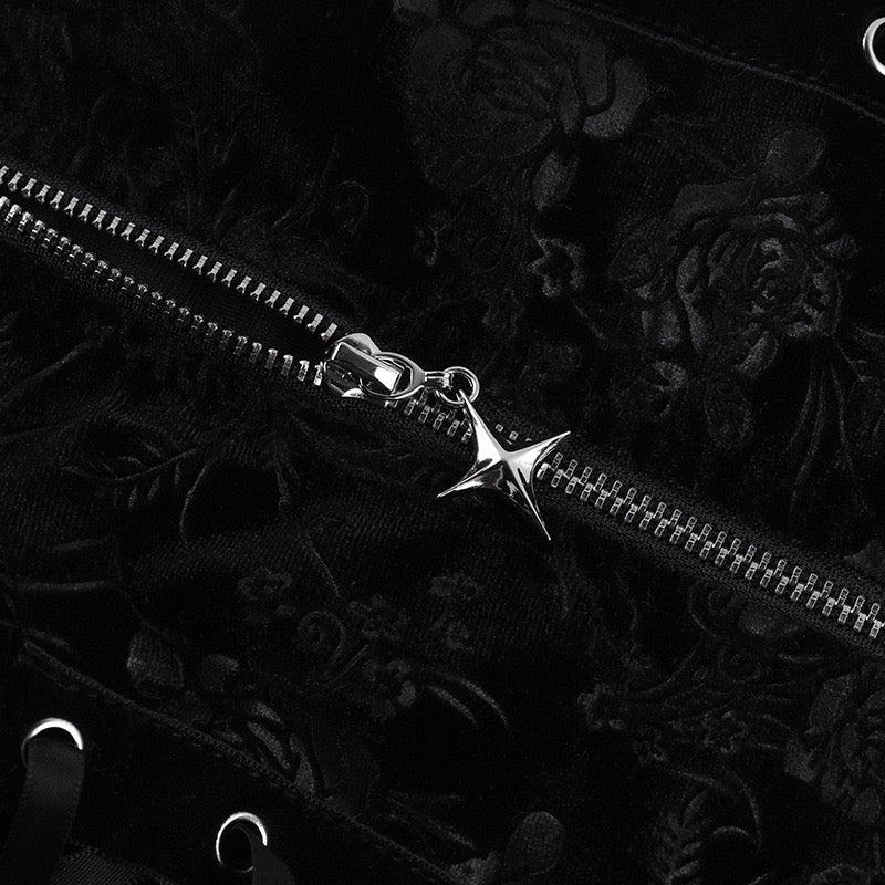 Silver zipper with a star-shaped pull on a black floral background