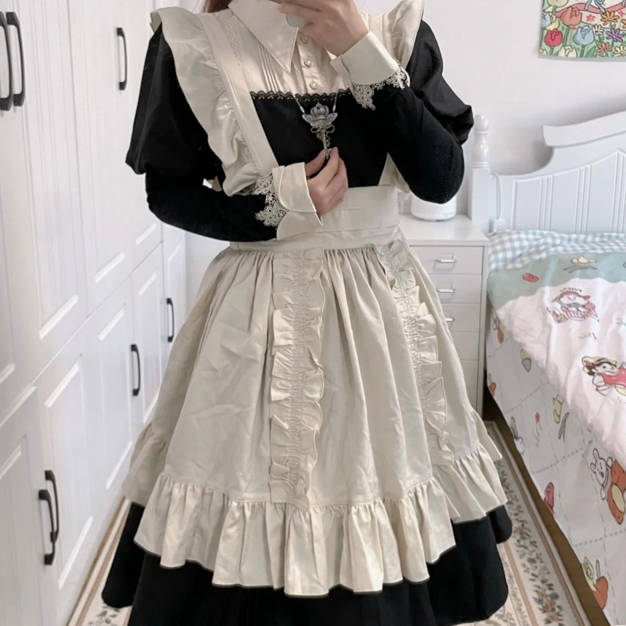 Person wearing a black and white outfit with ruffled details in a room.