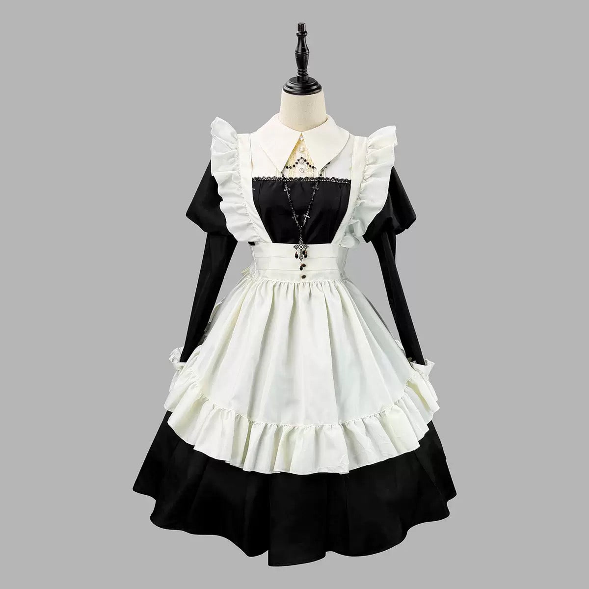 Black and white dress with ruffled details on a mannequin against a gray background