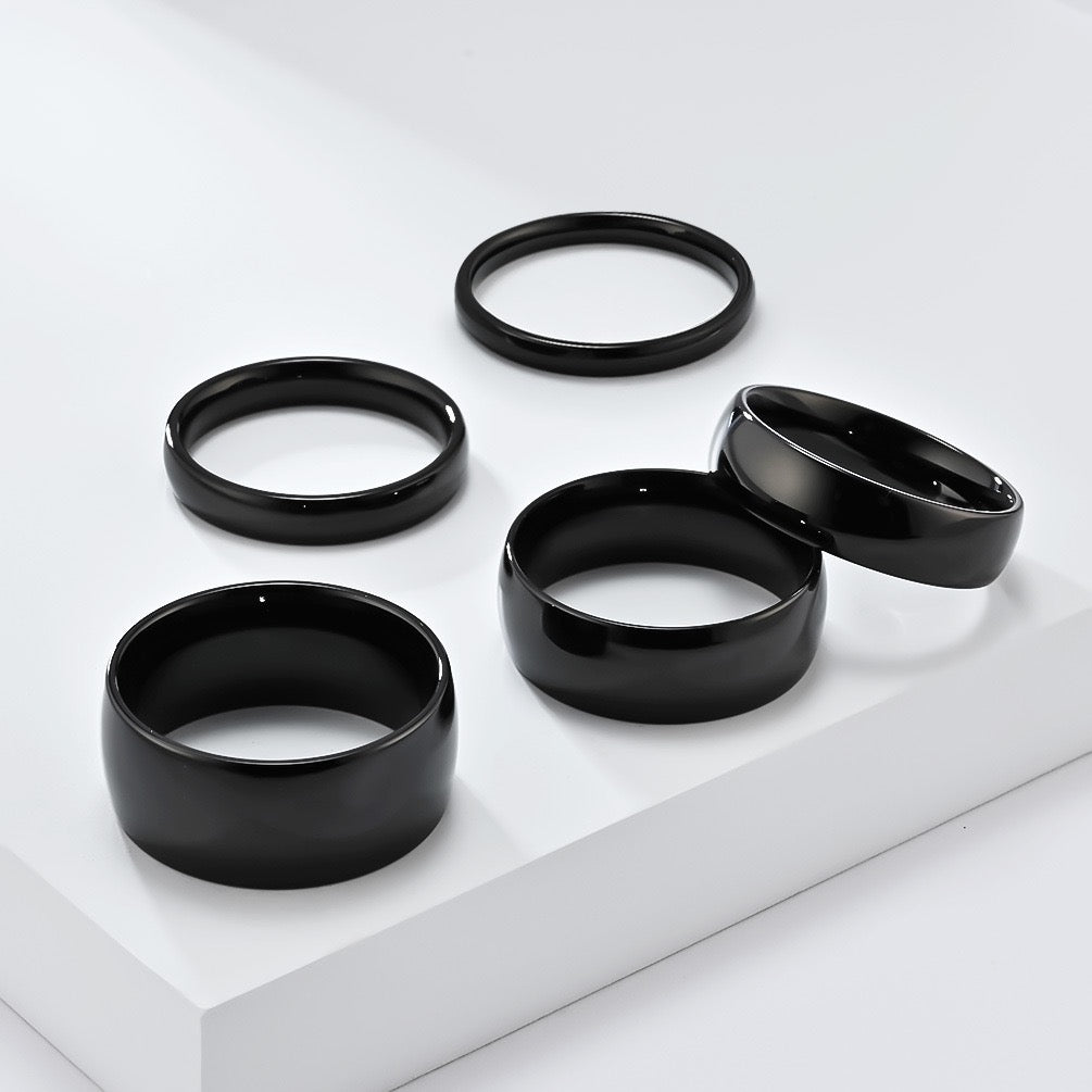 Set of black minimalism stainless steel ring band on a white surface