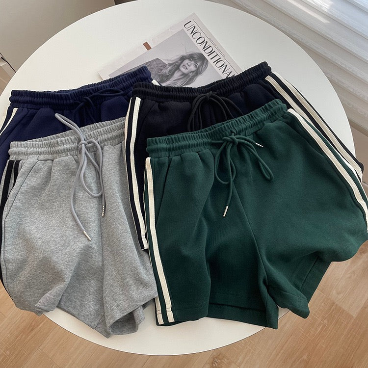 Four pairs of shorts in different colors on a round white table.
