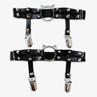 Black leather leg garters with silver studs and clips on a white background