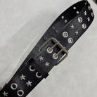 Black leather belt with silver star and round studs and buckles on a light gray backgroun