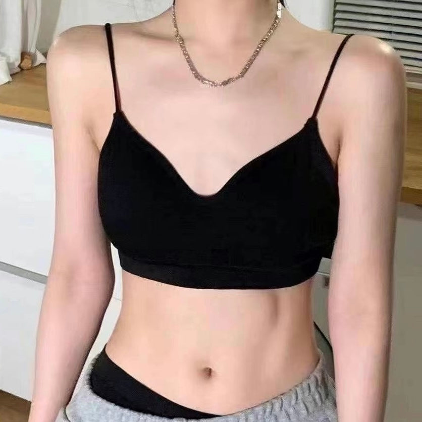 A sissy wearing a black spaghetti-strap camisole crop top with a scoop neckline, paired with gray sweatpants and a silver chain necklace.