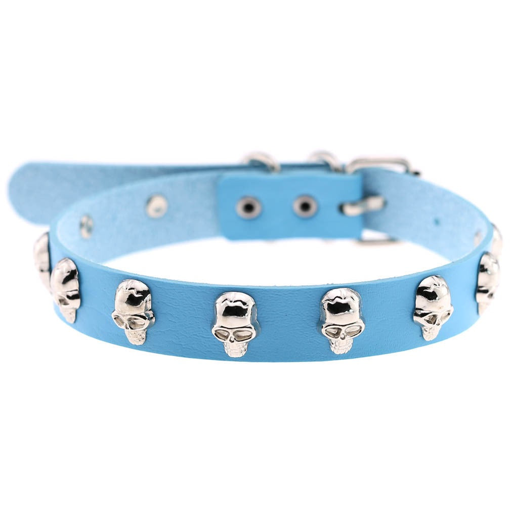 A light blue leather collar decorated with multiple silver skull studs, shown against a plain white background.