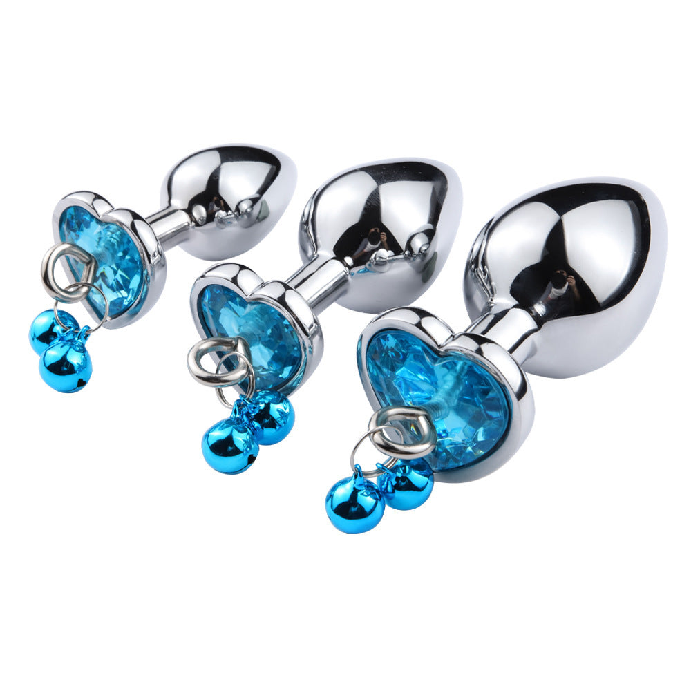 Metallic anal plugs with blue gemstones on a white background