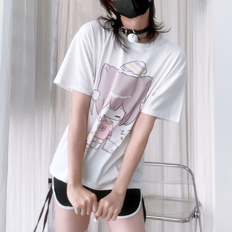 Person wearing a white t-shirt with a cartoon design in front of a white curtain.