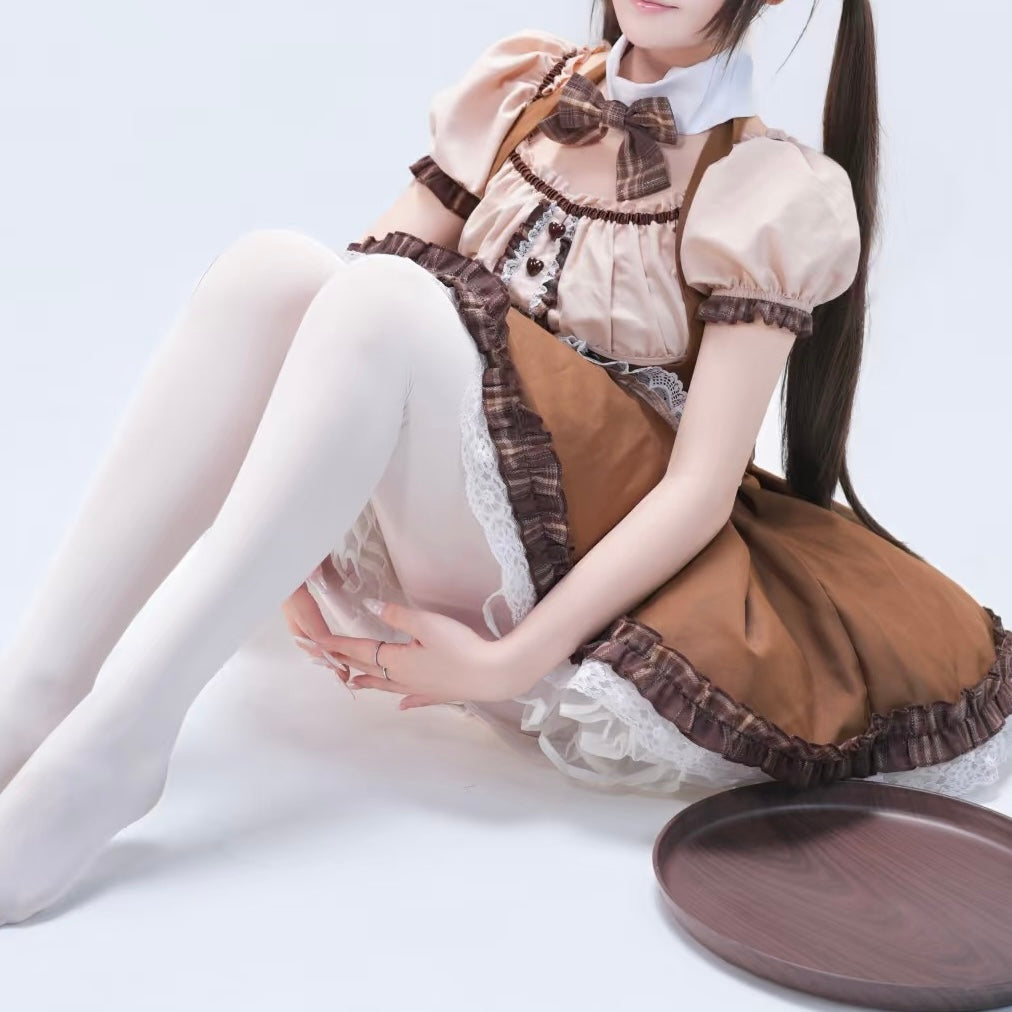 Femboy wearing a brown maid outfit with white stockings sitting on a white surface.