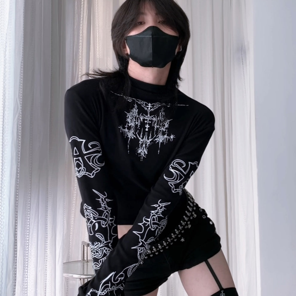Person wearing a black long-sleeve shirt with a sun and moon design, black skirt, and striped leggings.