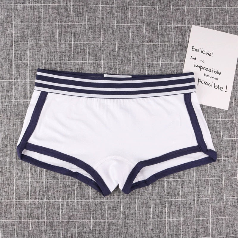 White boyshorts panty with navy trim on a textured gray background