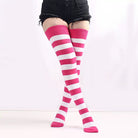 Pink and white striped knee-high socks worn with black shorts on a white background