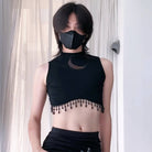 Person wearing a black sleeveless top with fringe details and a matching face mask.