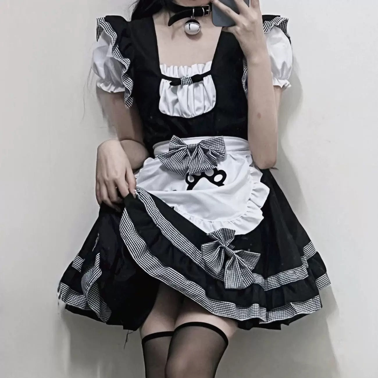 Person wearing a black and white cat femboy cosplay maid dress