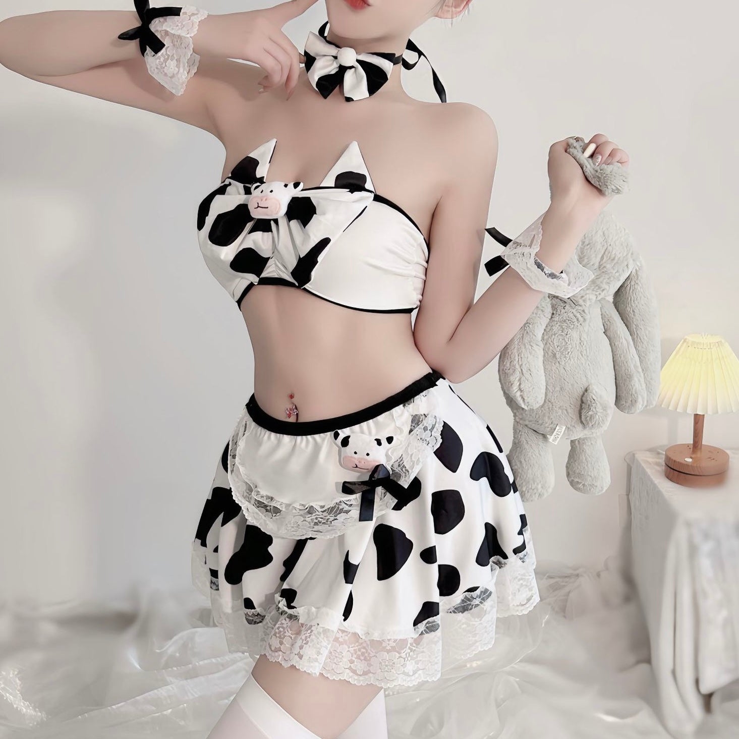 Person wearing a cow print outfit with a white background