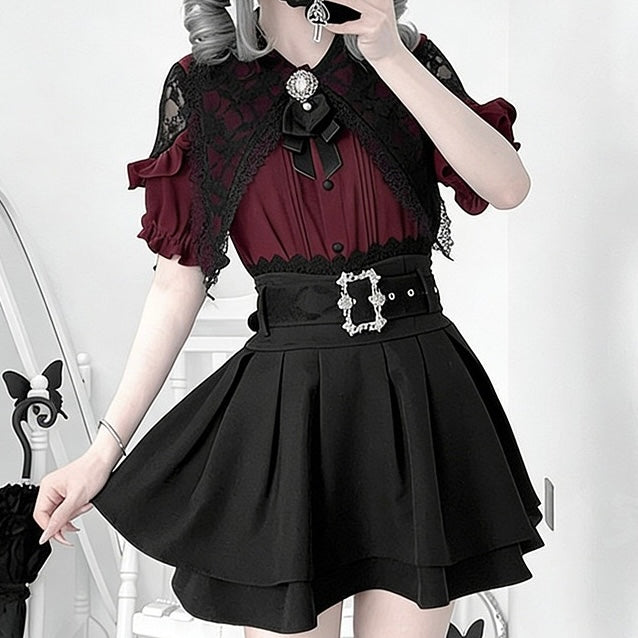 A model wearing a gothic-style dress with a deep burgundy blouse, black lace flutter sleeves, a black waist belt with silver rhinestone embellishments, and a black pleated skirt.