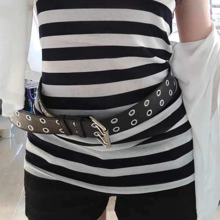 Person wearing a black and white striped shirt with a belt
