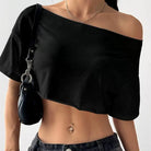 Person wearing a black off-shoulder top with a plain background