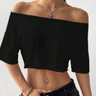 Black off-shoulder top worn by a person on a plain background