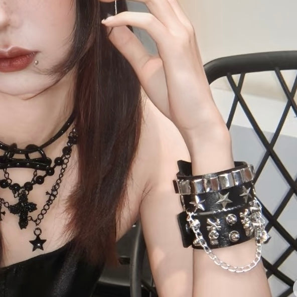 Close-up of a person wearing black gothic skull leather bracelets with a blurred background