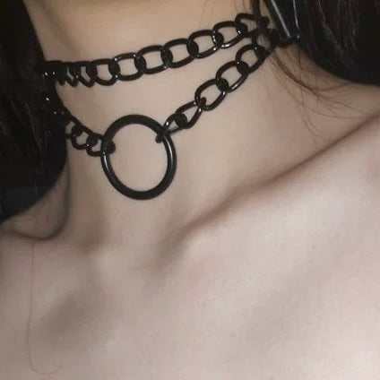 Close-up of a black chain choker necklace on a person's neck.