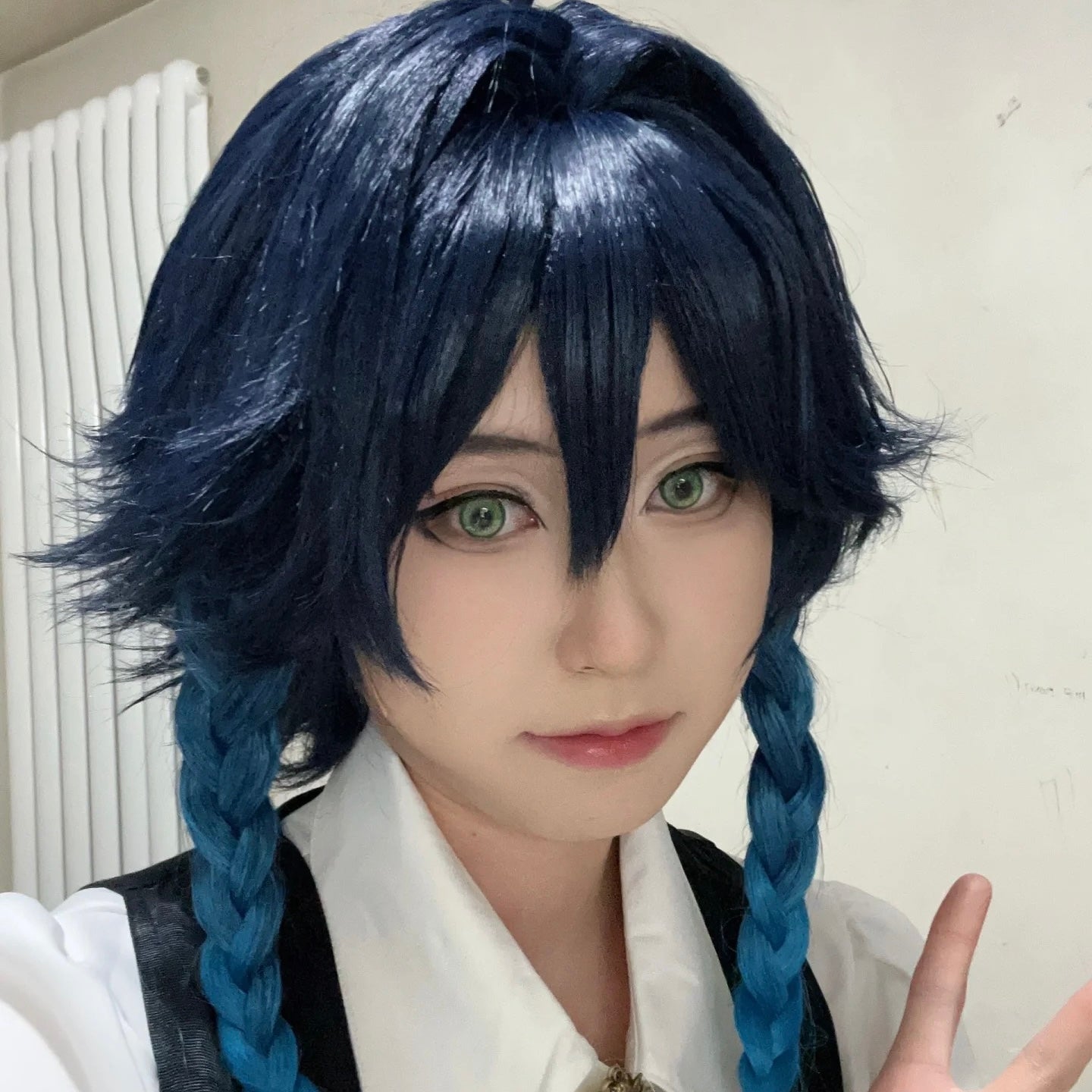 Person with blue hair styled in braids wearing a white shirt.