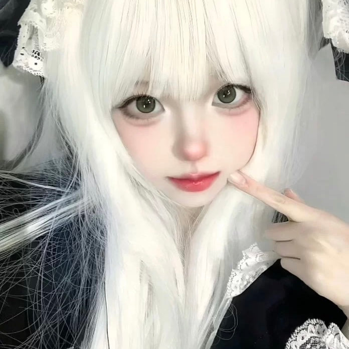 Person with long white hair and a black outfit with lace details, making a peace sign.