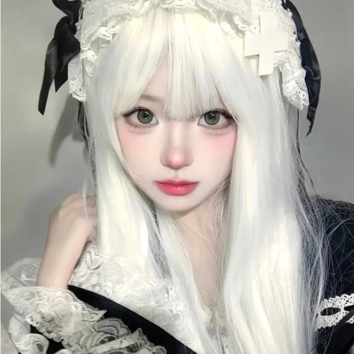Person with long white hair and decorative headpiece against a neutral background