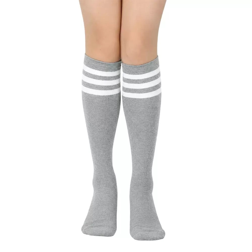 Gray knee-high socks with white stripes worn by a femboy on a white background