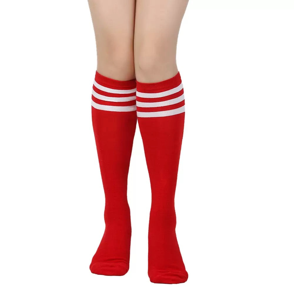 Red knee-high socks with white stripes worn by a femboy on a white background