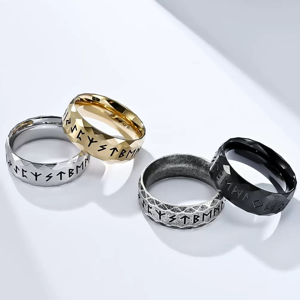 Four rings in gold, silver, and black on a white background
