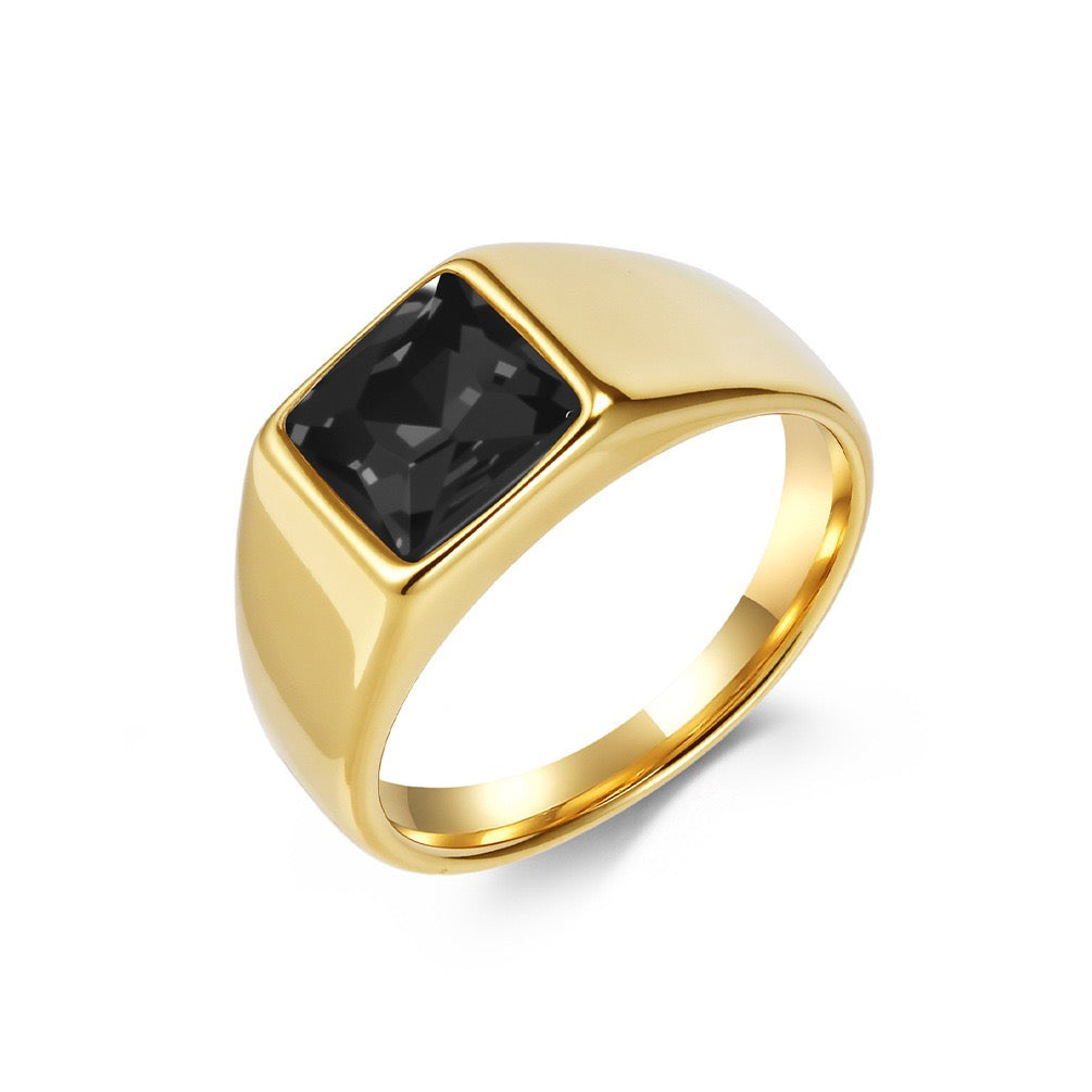 Gold ring with a black gemstone on a white background
