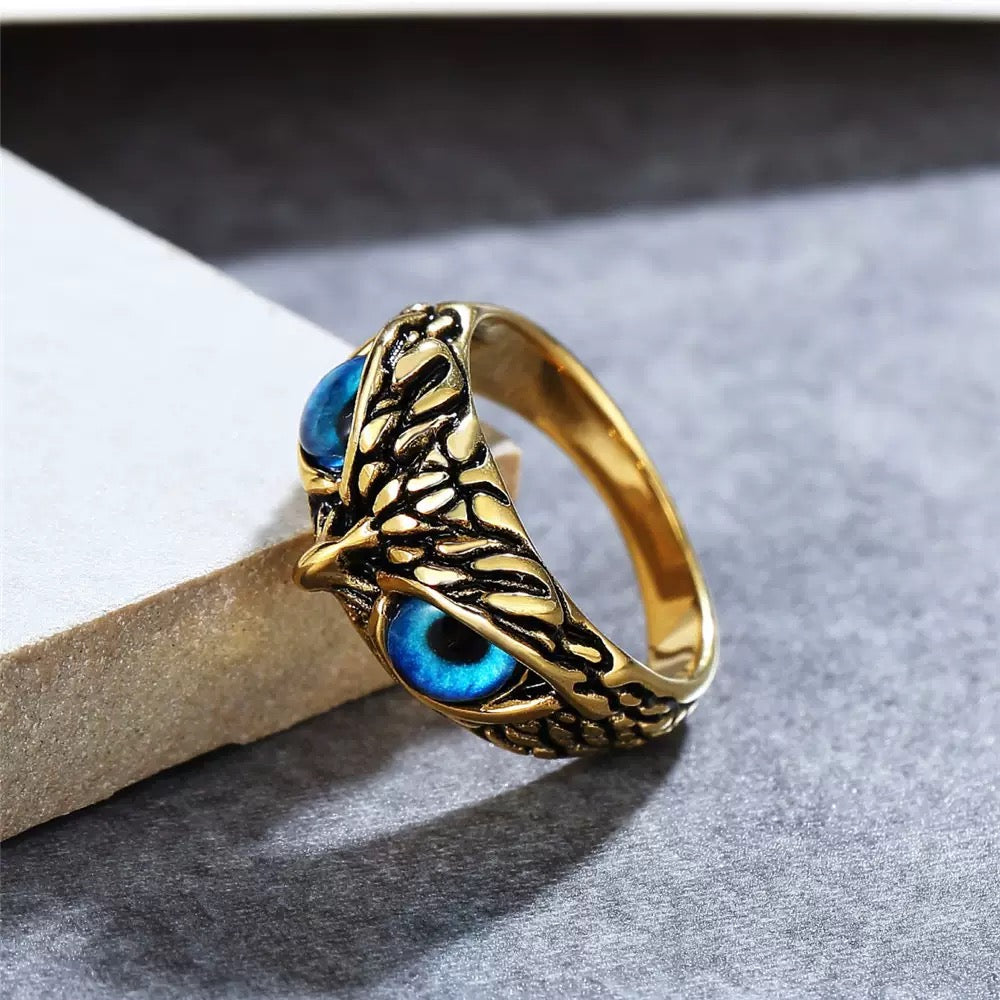 Gold ring with blue gemstone on a gray surface
