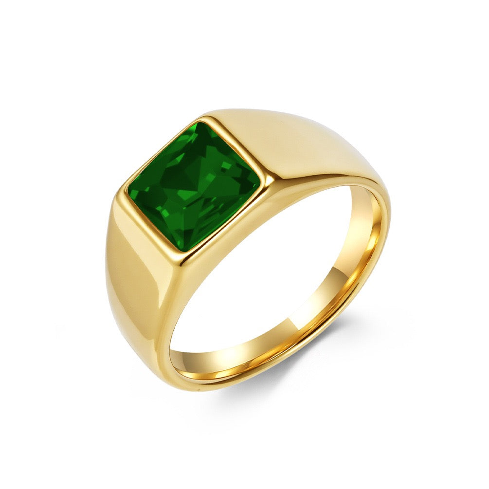 Gold ring with a green gemstone on a white background