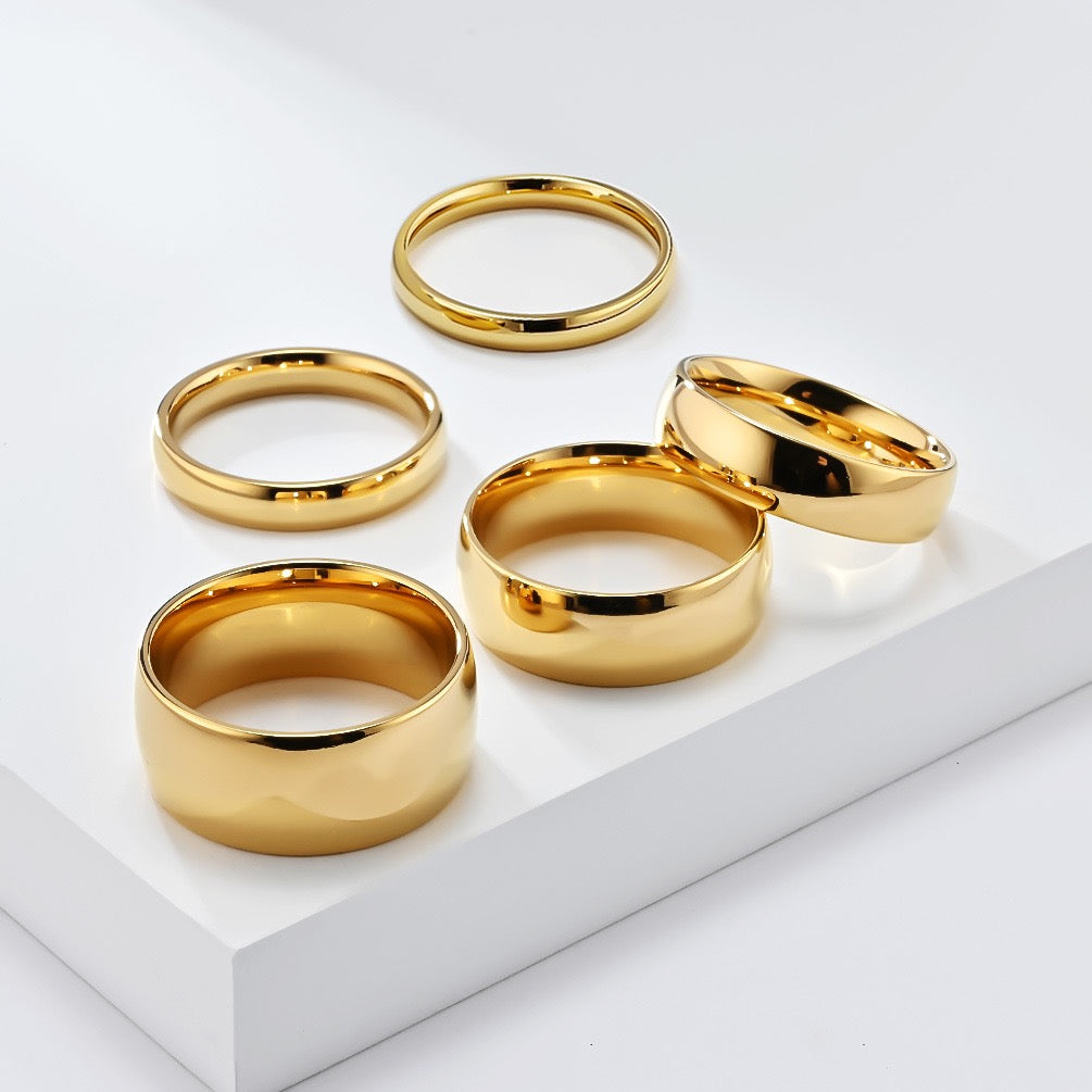 Set of gold minimalism stainless steel ring band on a white surface