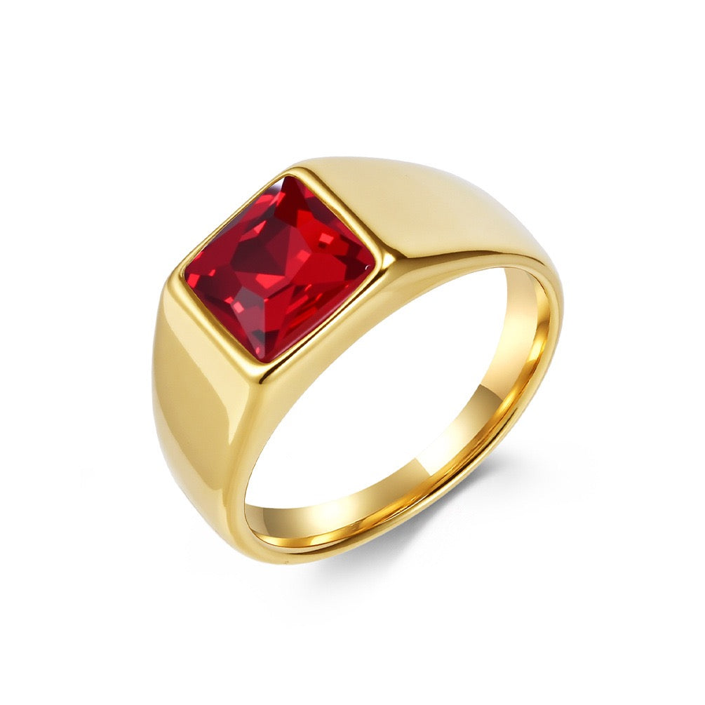 Gold ring with a red gemstone on a white background