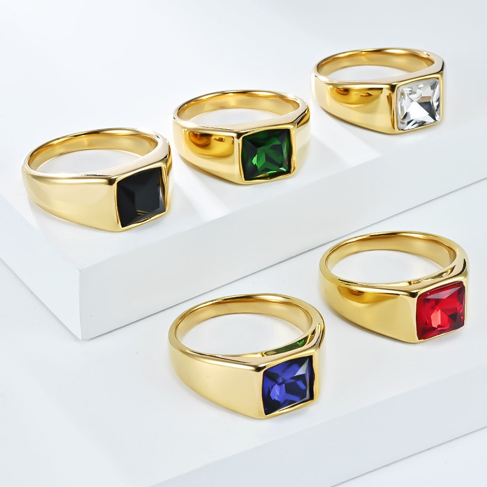 Set of gold rings with colored gemstones on a white background