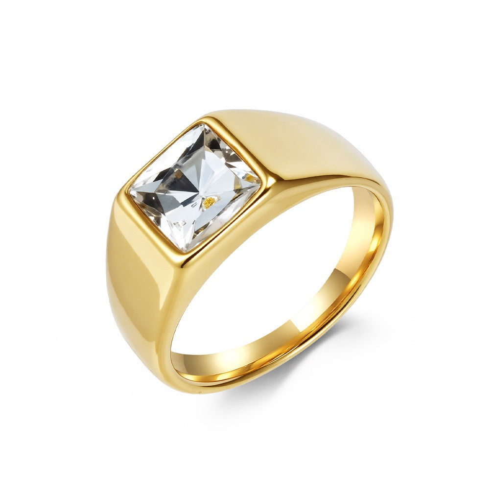 Gold ring with a clear gemstone on a white background