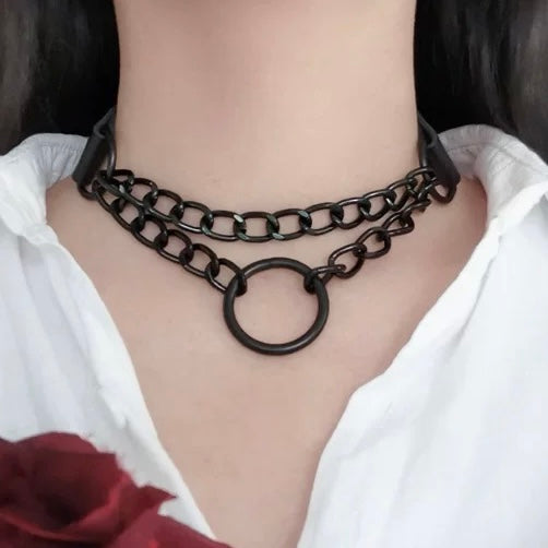 Person wearing a black chain necklace with a white shirt