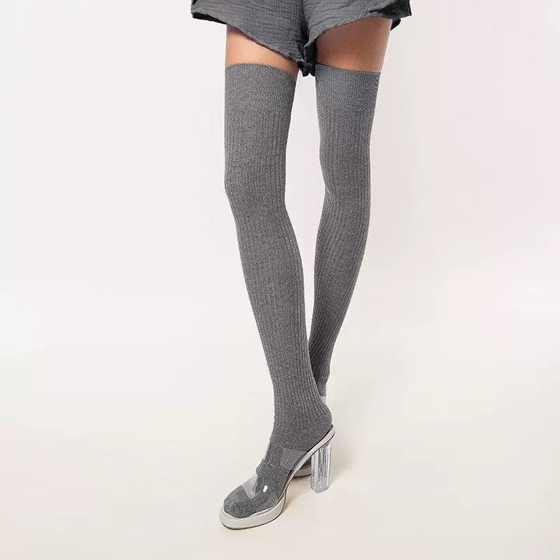 Gray thigh-high socks worn with a skirt on a white background