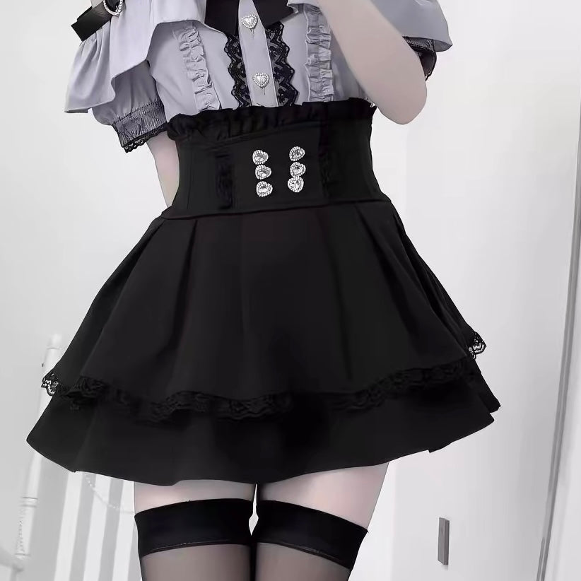Person wearing a black pinafore dress with heart details over a light blue shirt.